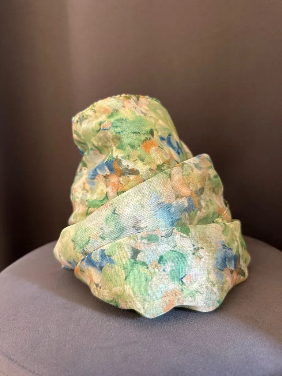 foulard in viscosa a fiori su base verde e rifiniture pesca, blu, celeste. Abbinala con una maglietta a manica corta e jeans o come stola durante una cerimonia
