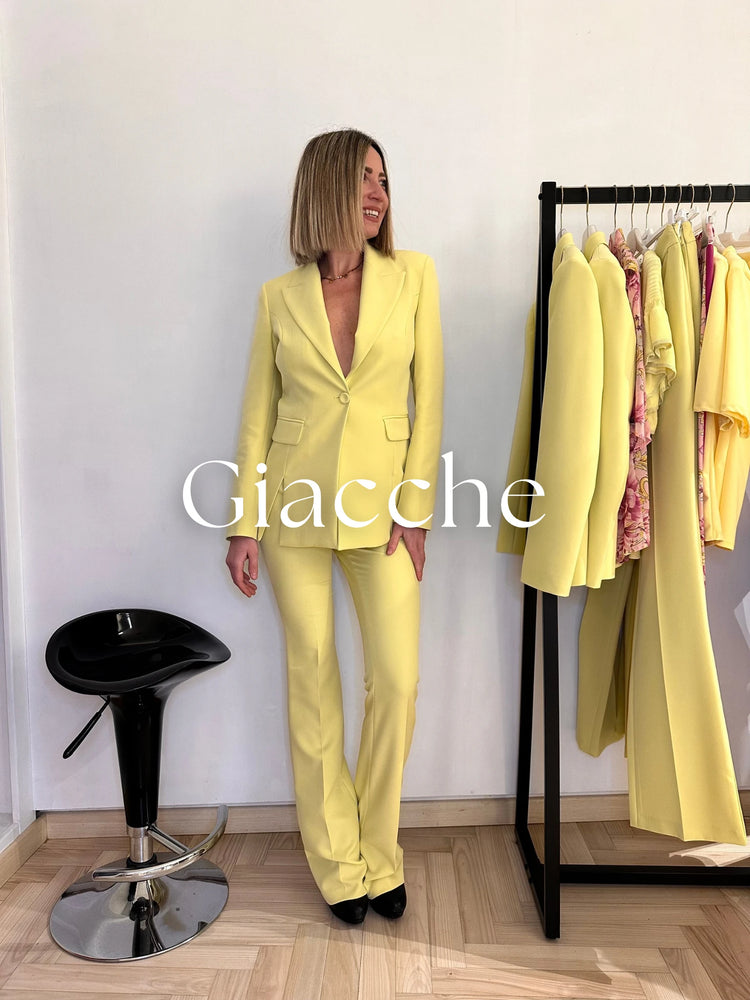 Modella indossa un cappotto bianco con vestito nero abbinato con stivaletto neri