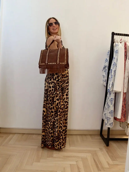 modella bionda che indossa un abito lungo animalier abbinato con la borsa marrone, cintura nera e occhiali marroni 