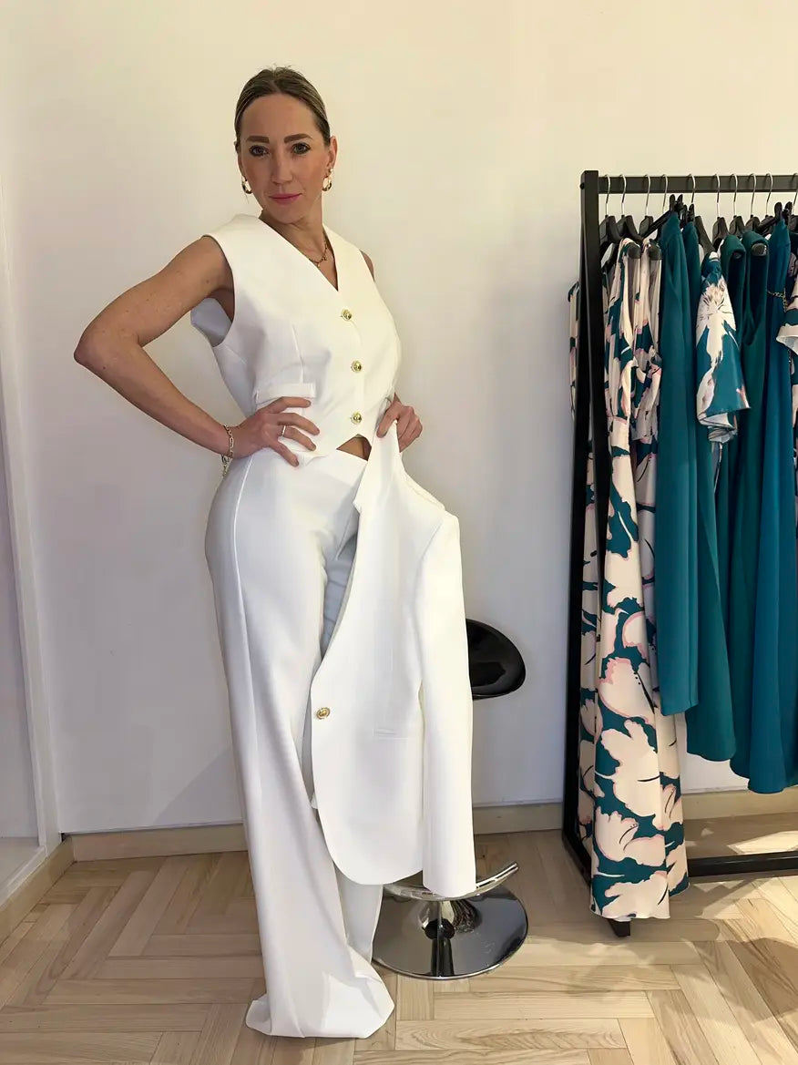 Completo elegante total white Claset con gilet smanicato pantalone palazzo e blazer abbinato con bottoni oro indossato da modella in boutique