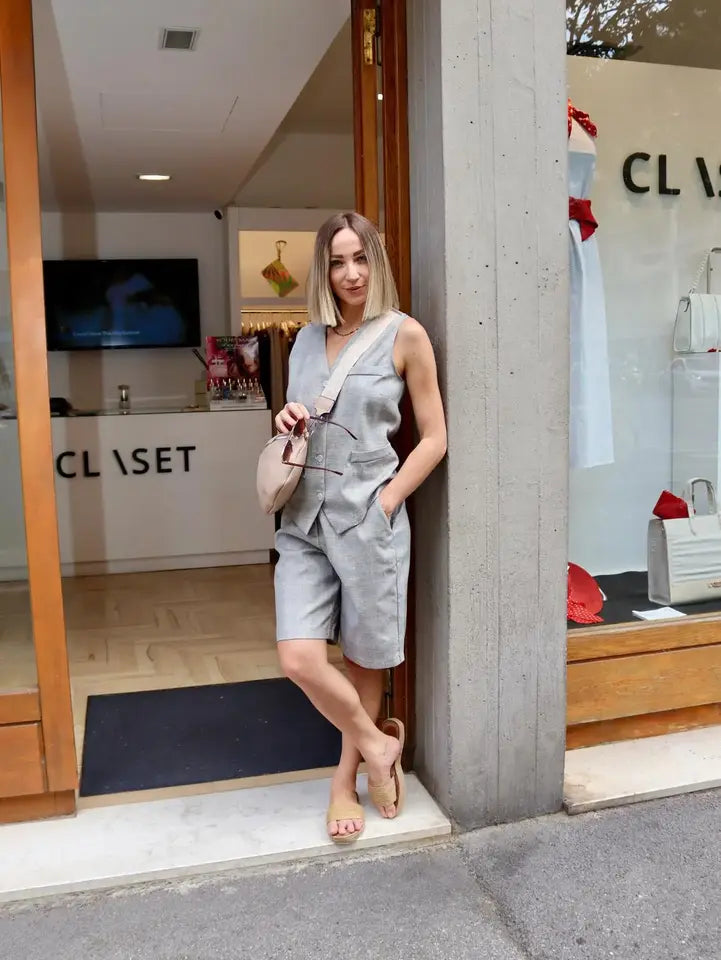 modella bionda che indossa un gilet con bottoni frontali stile scozzese abbinato con il suo bermuda davanti a claset firenze