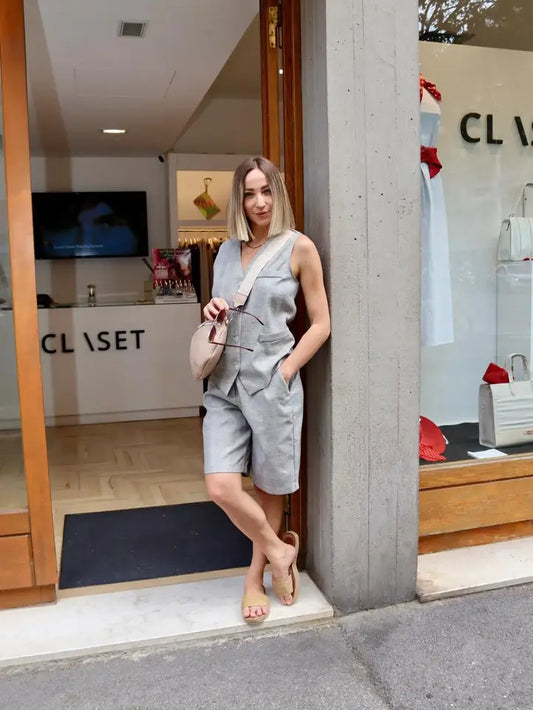 modella bionda che indossa un gilet con bottoni frontali stile scozzese abbinato con il suo bermuda davanti a claset firenze