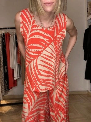 bionda che indossa un top in fantasia tropicale color corallo e corda di viscosa