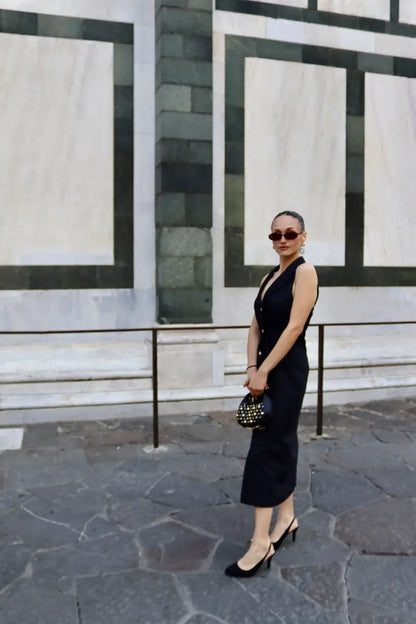 Modella bionda che indossa un abito midi nero dal taglio sartoriale sulle vie di firenze