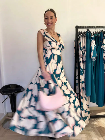 Abito lungo effetto satinato con fantasia a fiori e scollo a V indossato dalla modella in negozio Claset Firenze, un capo erfetto per una cerimonia 