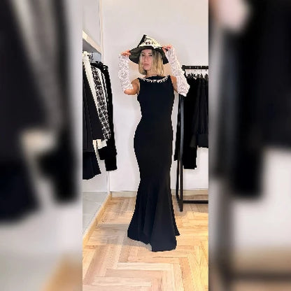 abito lungo stile sirena indossato da modella con cappello strega 