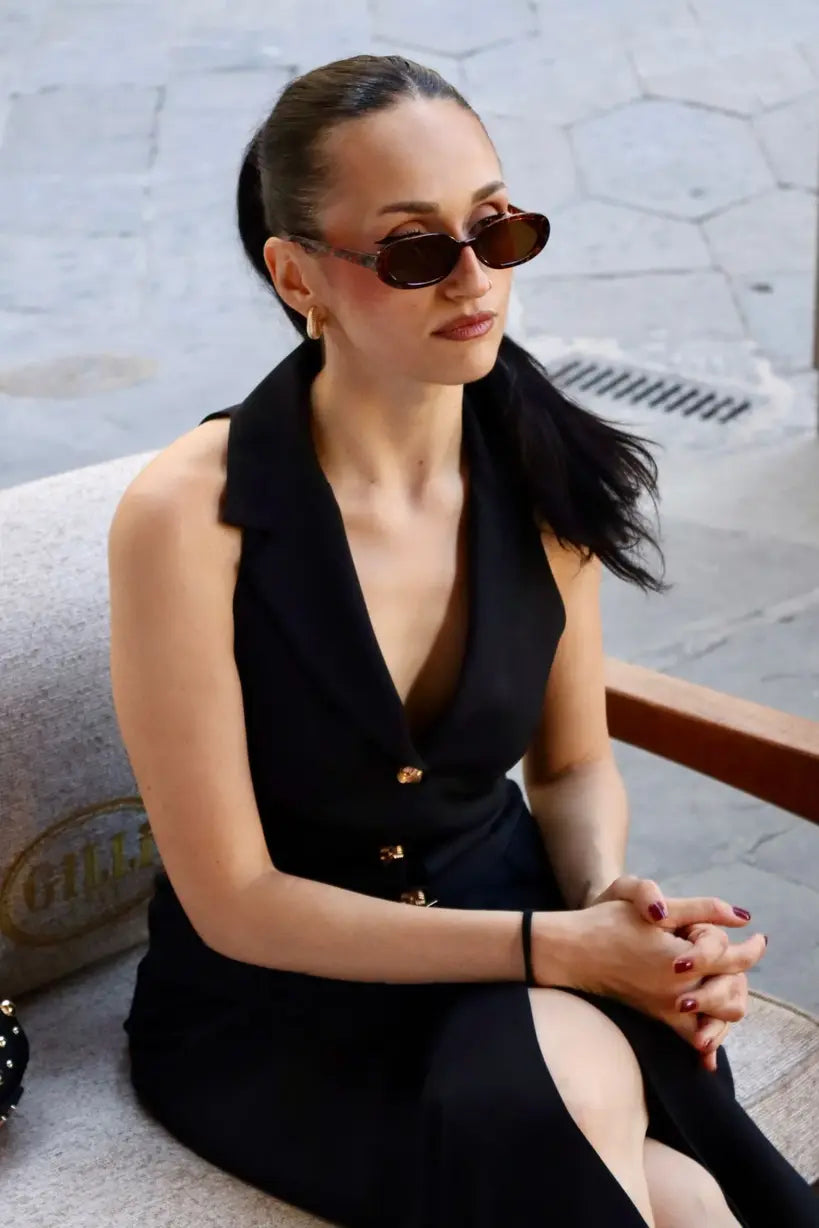 modella mora che indossa un abito midi sartoriale con bottoni frontali in gioiello oro
