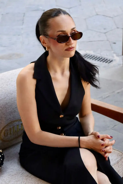 modella mora che indossa un abito midi sartoriale con bottoni frontali in gioiello oro