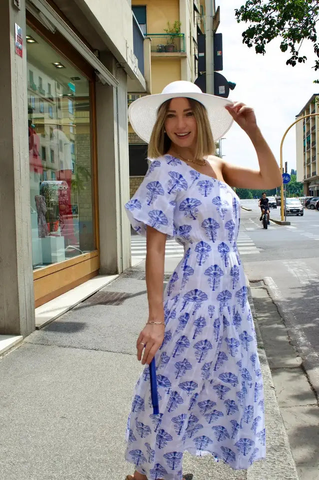 modella bionda che indossa davanti al negozio un abito lungo con tinta bianca e lu