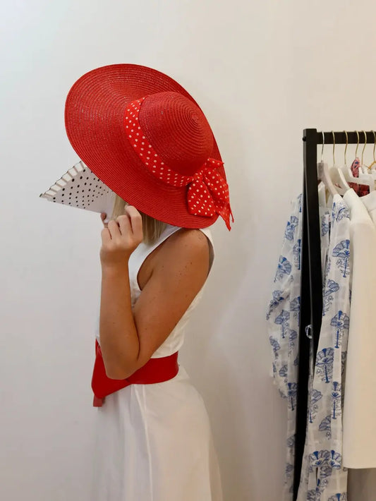 modella che indossa un cappello rosso con fascia a pois 