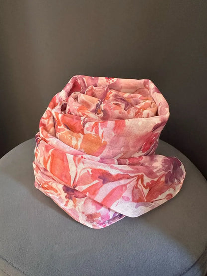 foulard in viscosa, fantasia a fiori di colore fuxia, arancione, tracce di lilla e base rosa. Abbinala con un abito neutro di colore panna 