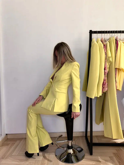 donna in posa seduta su sgabello con , giacca sartoriale monopetto e pantalone, giallo, elegante .Claset Firenze 