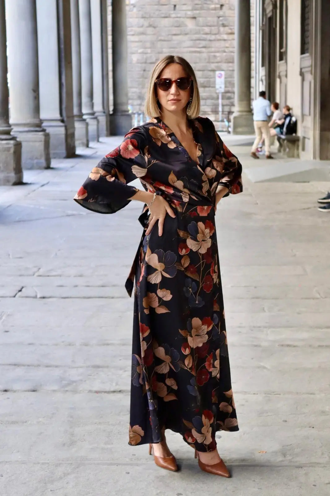 modella bionda che indossa agli uffizi un kimono a base nera on fiori dorati e blu, un capo perfetto per un evento elegante