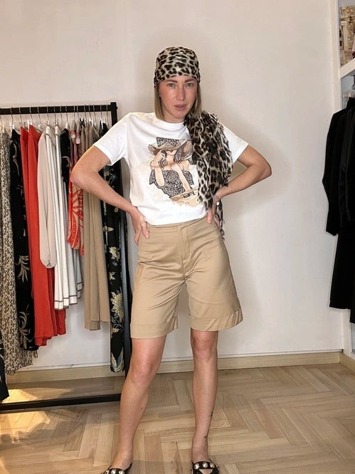 modella che indossa una t-shirt di cotone su base bianca con dettagli di donna raffigurata ed un cappello maxi