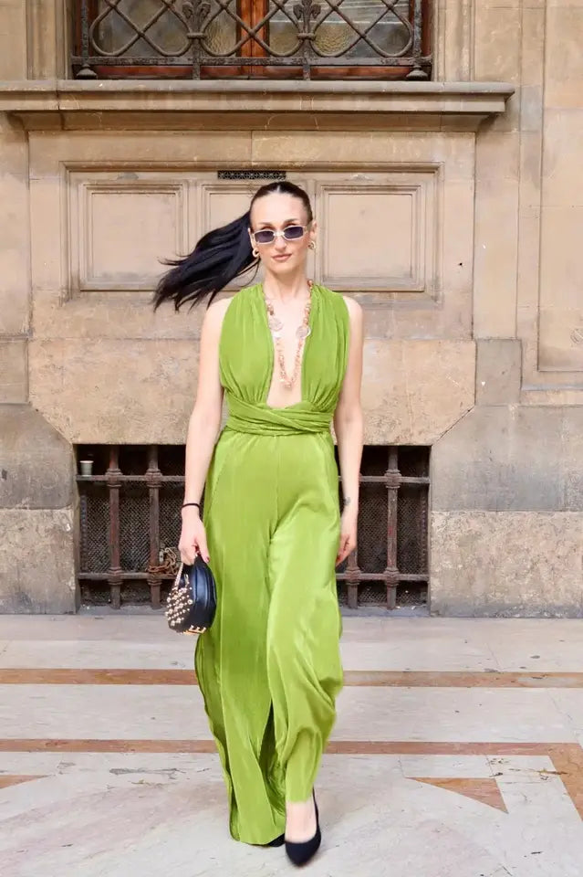 modella mora che indossa una tuta verde con scollatura a v sia dietro che davanti 